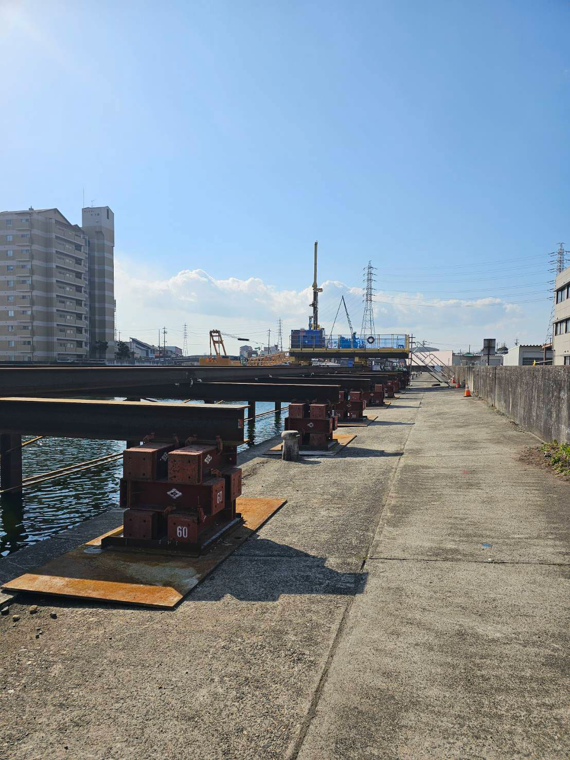 河川沿いで仮設工事を行う建設現場の様子
