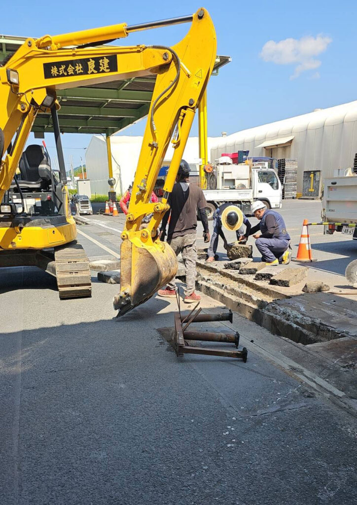 舗装道路の掘削作業中の現場作業員